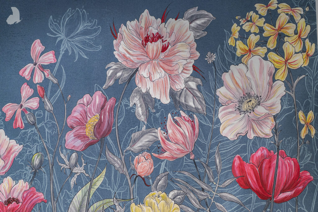 Foto einer blauen Tapete mit großem floralen Muster in rosa, rot und goldgelben Farbtönen