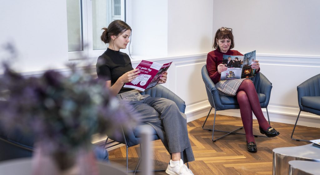 eine junge Frau und eine ältere Frau sitzen nebeneinander im Wartezimmer der gynäkologischen Praxis Dr. Priese und Dr. Stecher